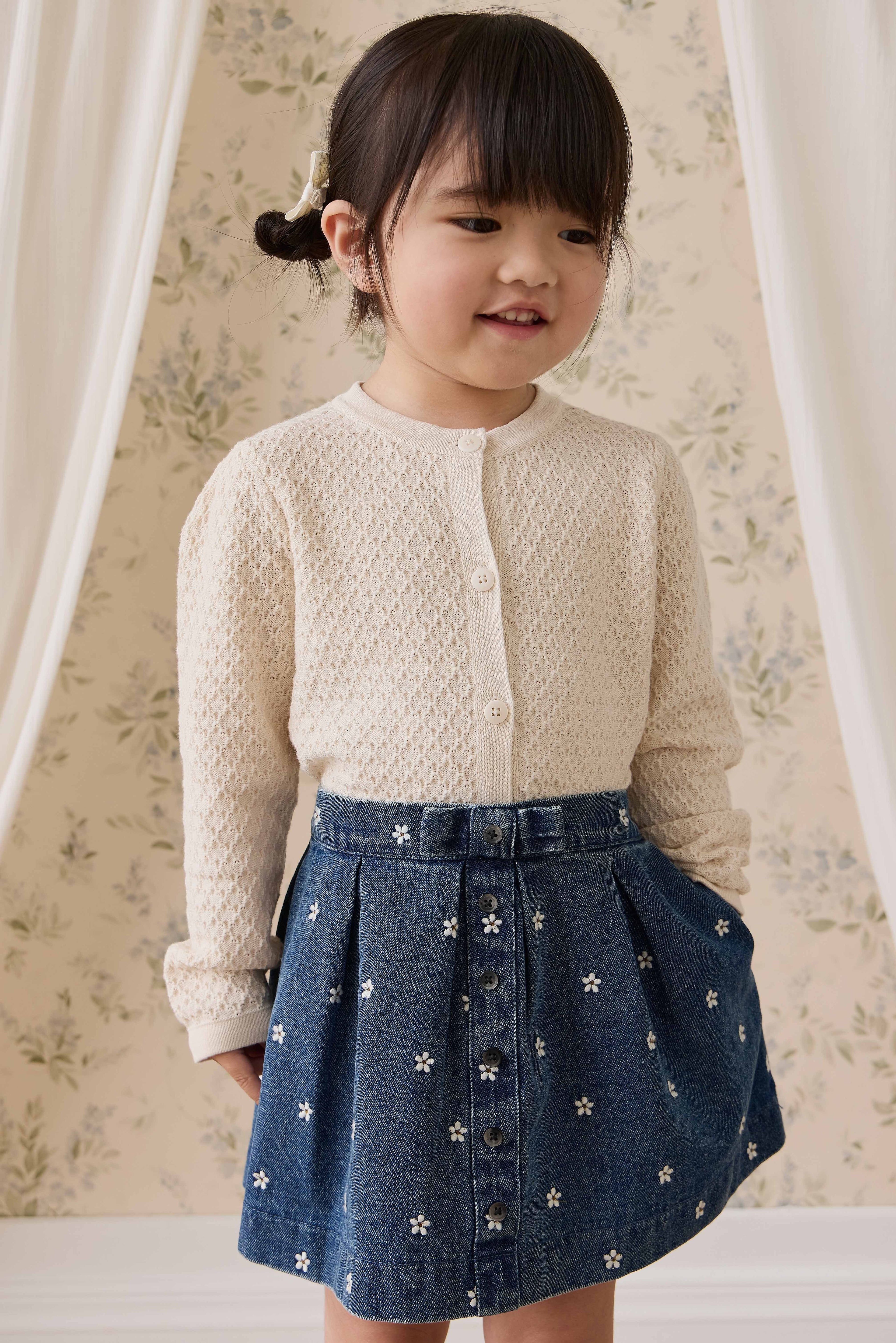 Jupe plissée évasée en jean bleu pour fille avec broderies florales et boutonnage sur le devant