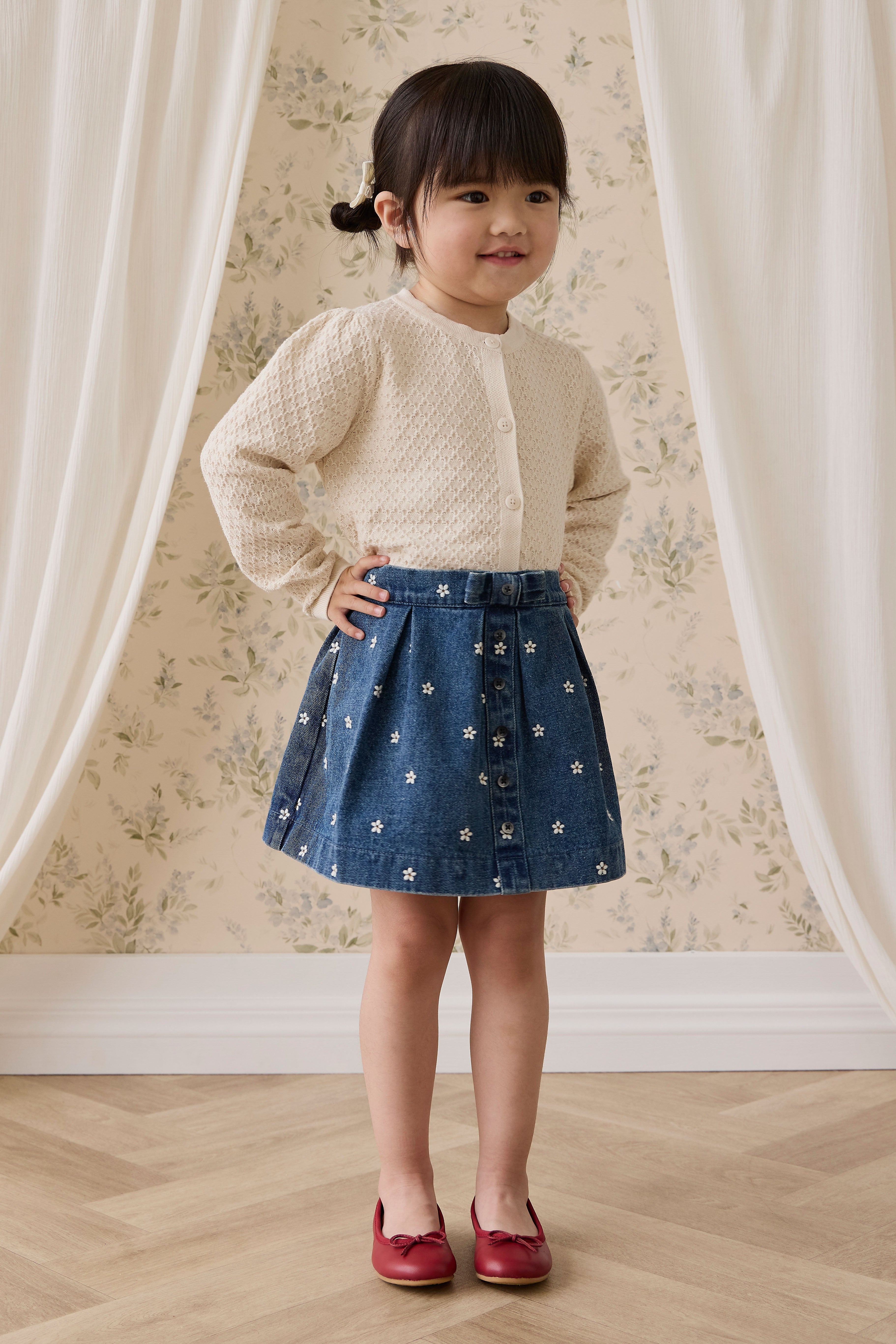 Jupe plissée évasée en jean bleu pour fille avec broderies florales et boutonnage sur le devant