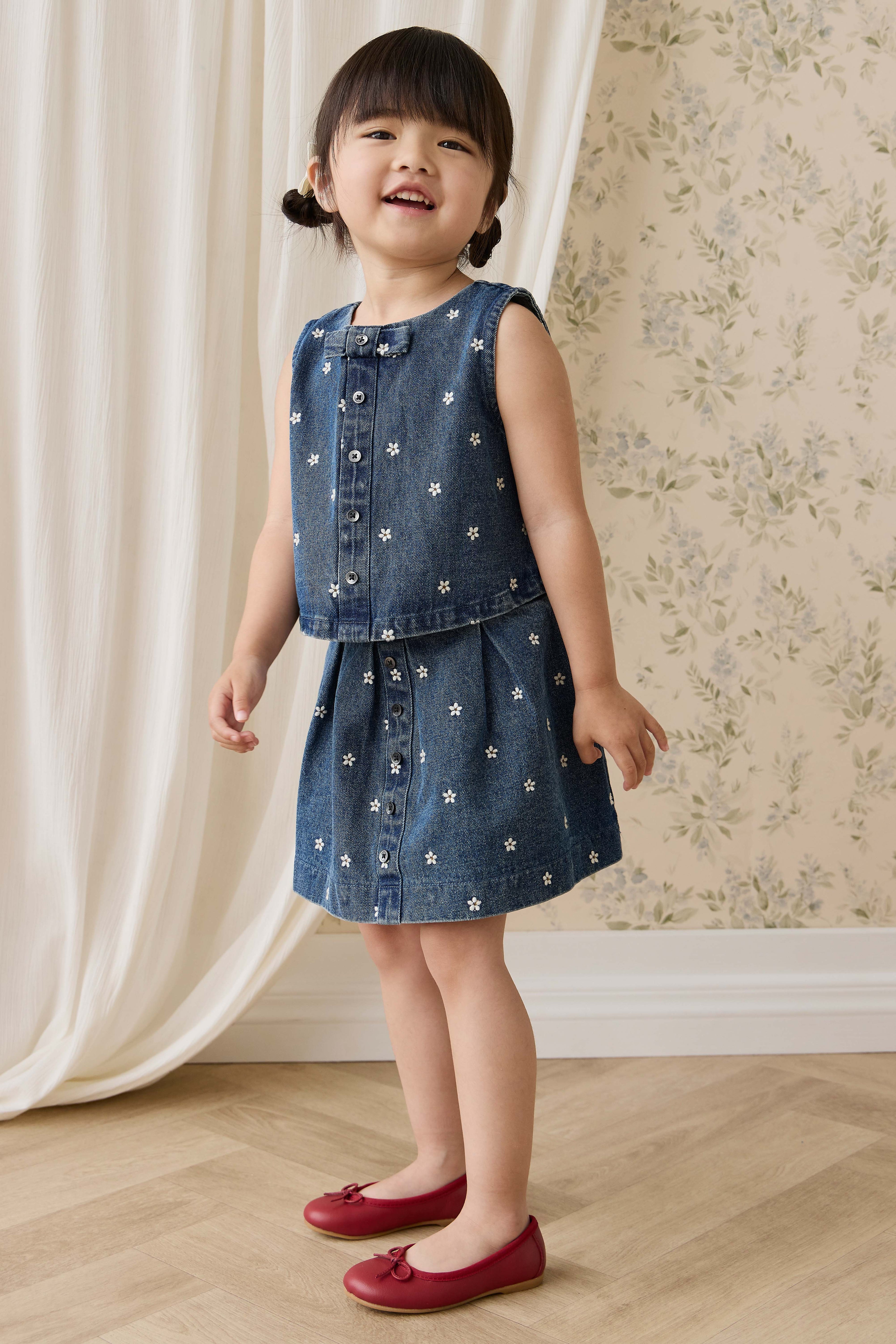 Jupe plissée évasée en jean bleu pour fille avec broderies florales et boutonnage sur le devant